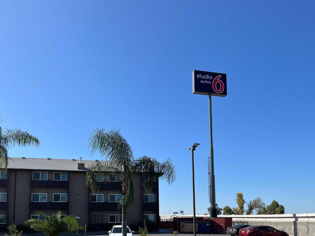una señal para un hotel frente a un edificio en Studio 6 Suites Delano, CA, en Delano