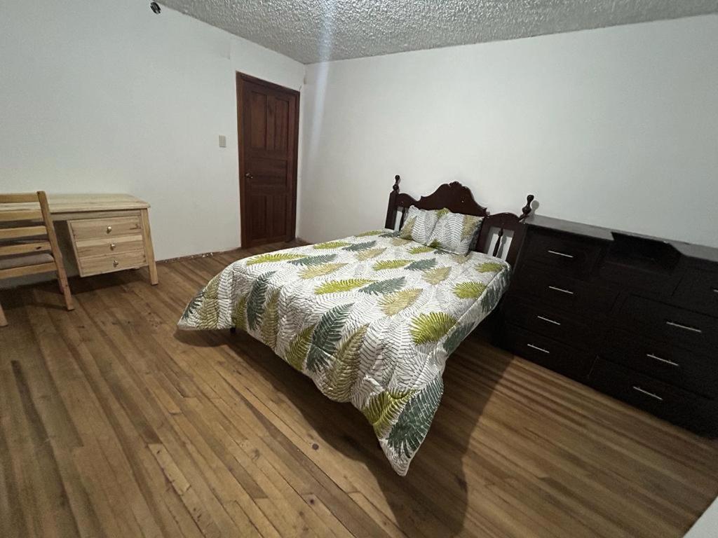 een slaapkamer met een bed en een dressoir bij Casa que te hará sentir como en casa! in Cuenca