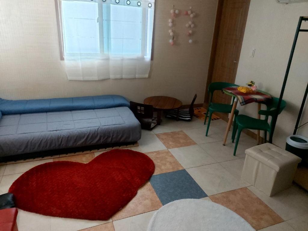 a living room with a red heart pillow on the floor at Seomun market Dongsan Hospital Cheongla Hill in Daegu