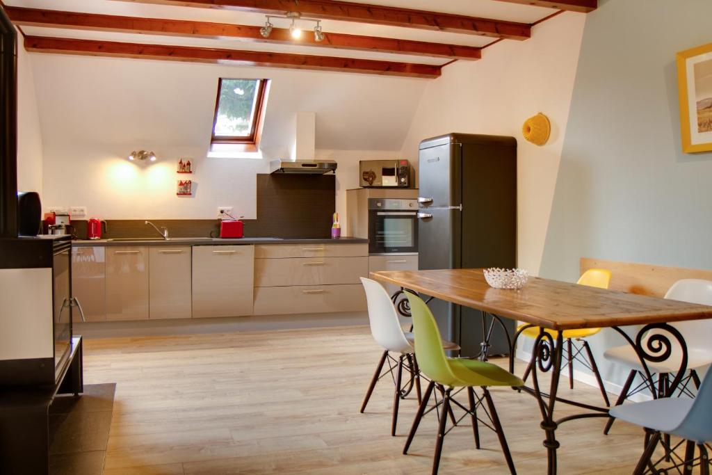 a kitchen with a wooden table and a refrigerator at La Parenthese in Gertwiller