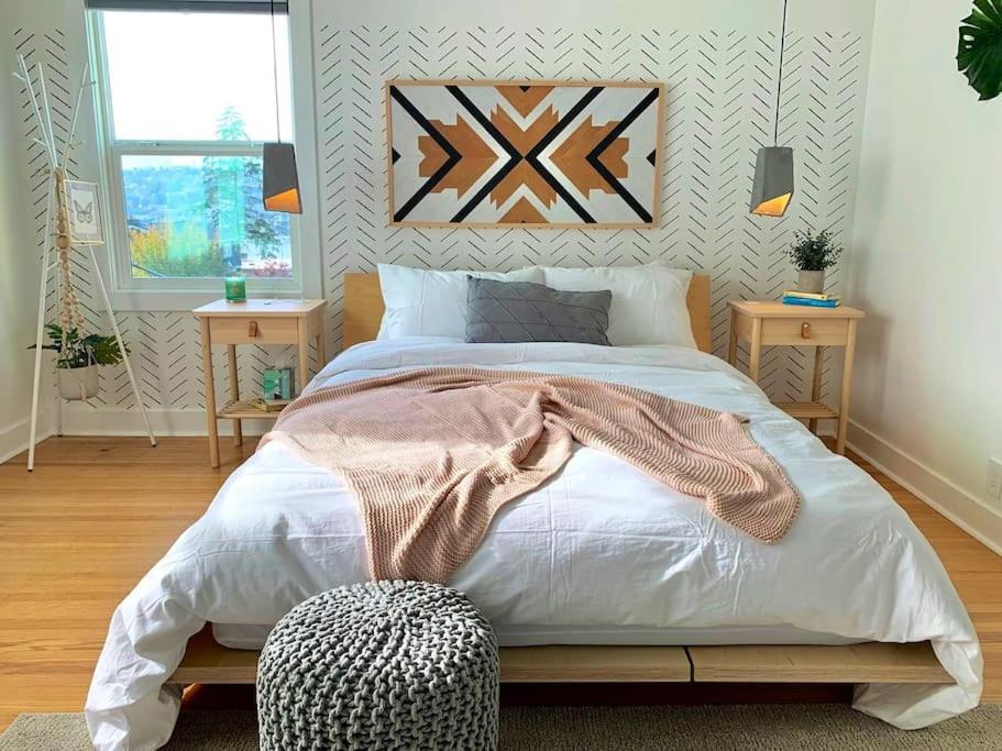una camera da letto con un grande letto con due tavolini di Modern Amenities & Chic Design in Heart of Seattle a Seattle