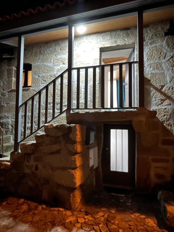 uma casa de pedra com uma escada e uma janela em Casa do Forno D`Aldeia em Mouços