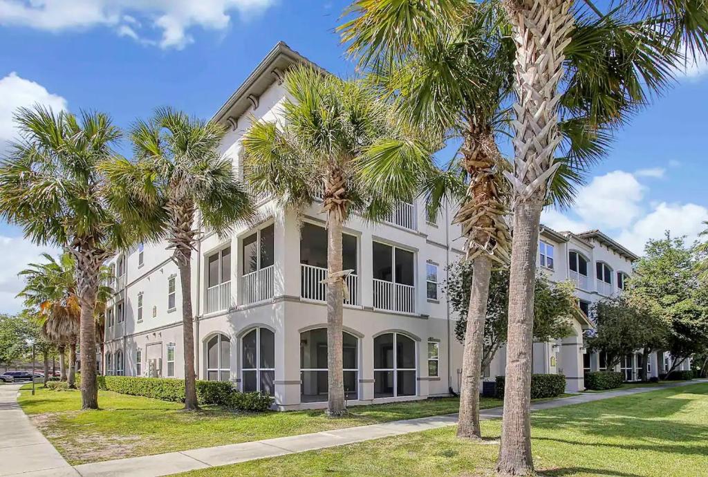 un grande edificio bianco con palme di fronte di Luxury Family Resort Styled Apartment Near Disney a Orlando