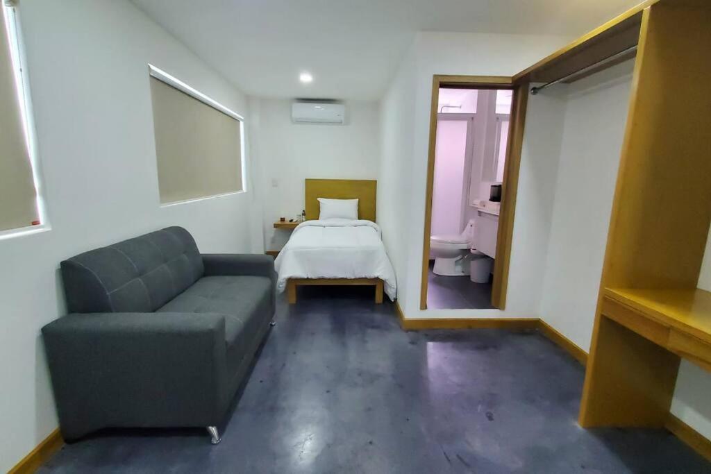 een kamer met een bank en een bed en een slaapkamer bij Excelente lugar para descansar.²⁰⁵ in Fortín de las Flores
