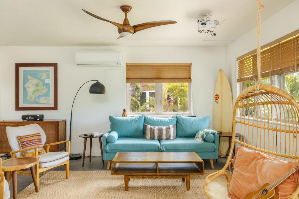 a living room with a blue couch and a swing at Earthy Beach House in Kailua-Kona