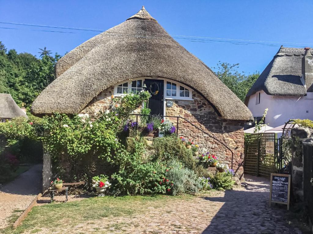 a cottage with a thatched roof at Granary Cottage in Torquay