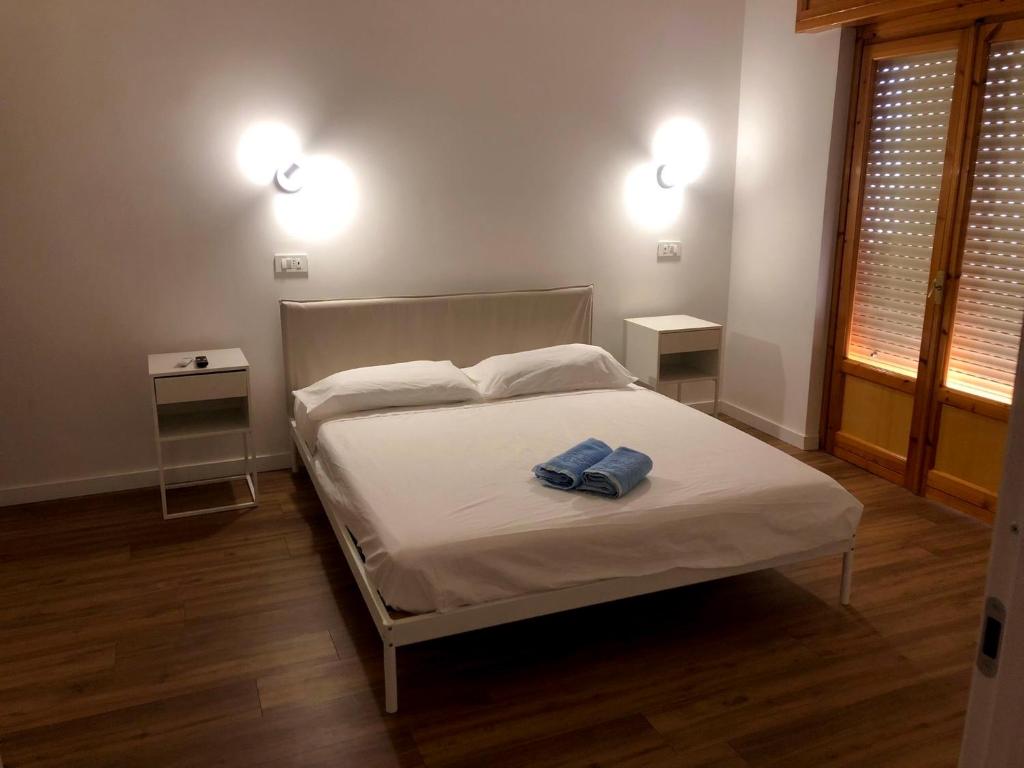 TOURIST HOUSE Le casette di Sofì في باغيريا: غرفة نوم بسرير ابيض مع مواقف ليلتين