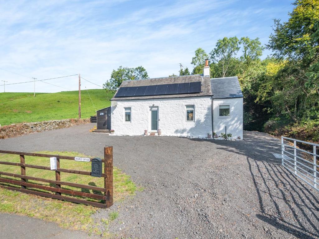 una casa blanca con una valla delante en Lincumtoy, en Ballantrae