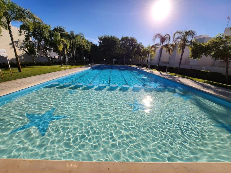 a large swimming pool with blue water and palm trees at Casa de 3 habitaciones TODAS con baño propio, 3 y medio baños en toal, alberca, cupo hasta 12 personas in Playa del Carmen