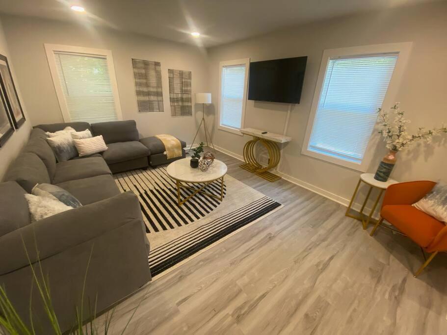 uma sala de estar com um sofá e uma mesa em East Point Atlanta - Spacious 5BR Retreat! em Atlanta