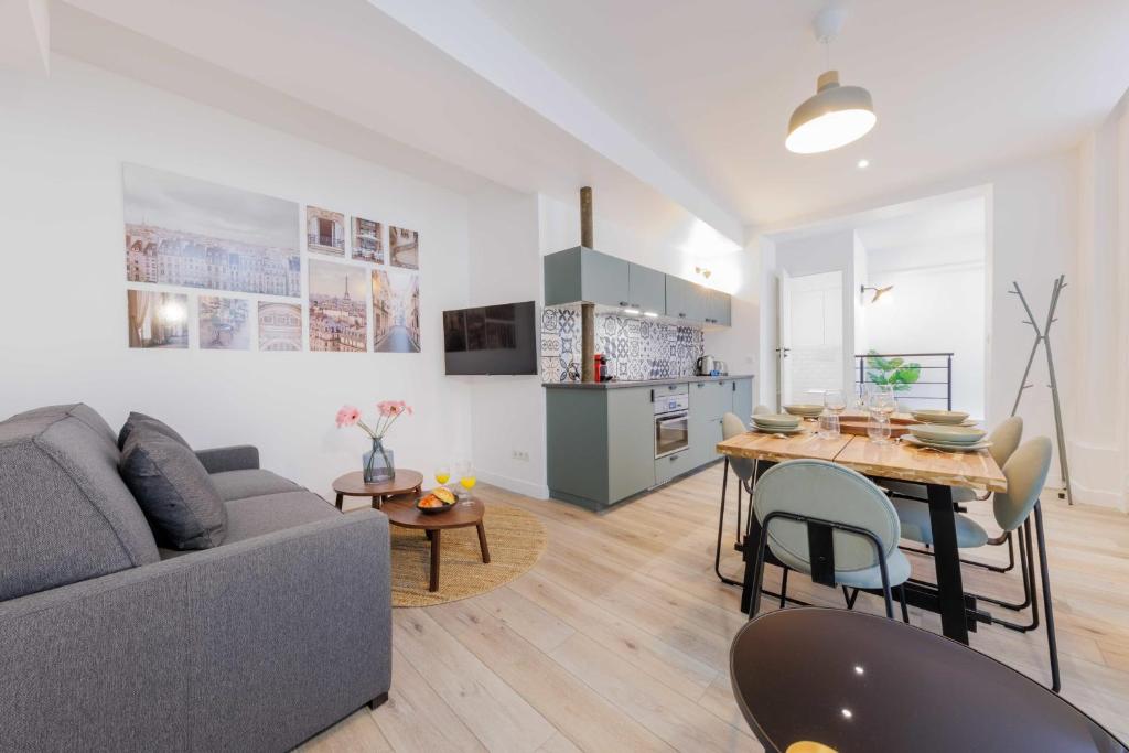 un salon avec un canapé et une table dans l'établissement Exceptionnel duplex à proximité de Montmartre!, à Paris