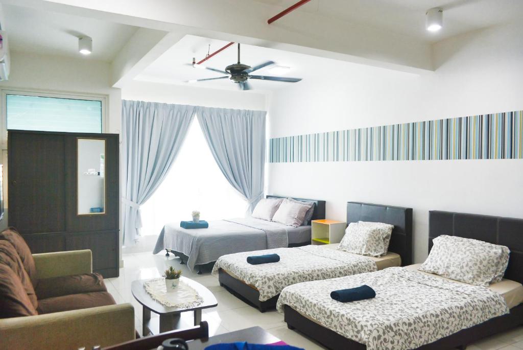 ein Wohnzimmer mit 2 Betten und einem Sofa in der Unterkunft FA Suite12 at DE CENTRUM PUTRAJAYA-BANGI in Kajang