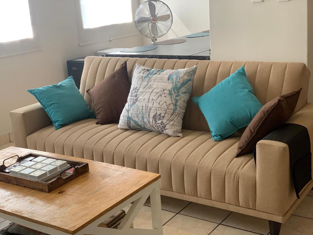 a couch with pillows and a coffee table in a living room at The Tipsy Expat in Paarl