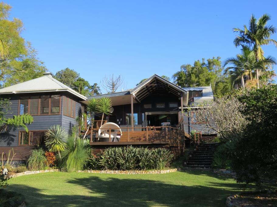 a large house with a porch and a yard at BELLINGEN CONVERTED CHURCH on the river (Pet Friendly) in Bellingen