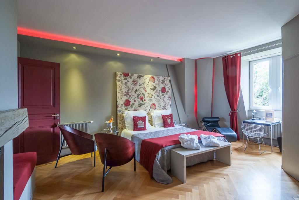 a hotel room with a bed, chair, table and lamps at Peonia at Home - Maison d'hôtes d'exception in Mulhouse