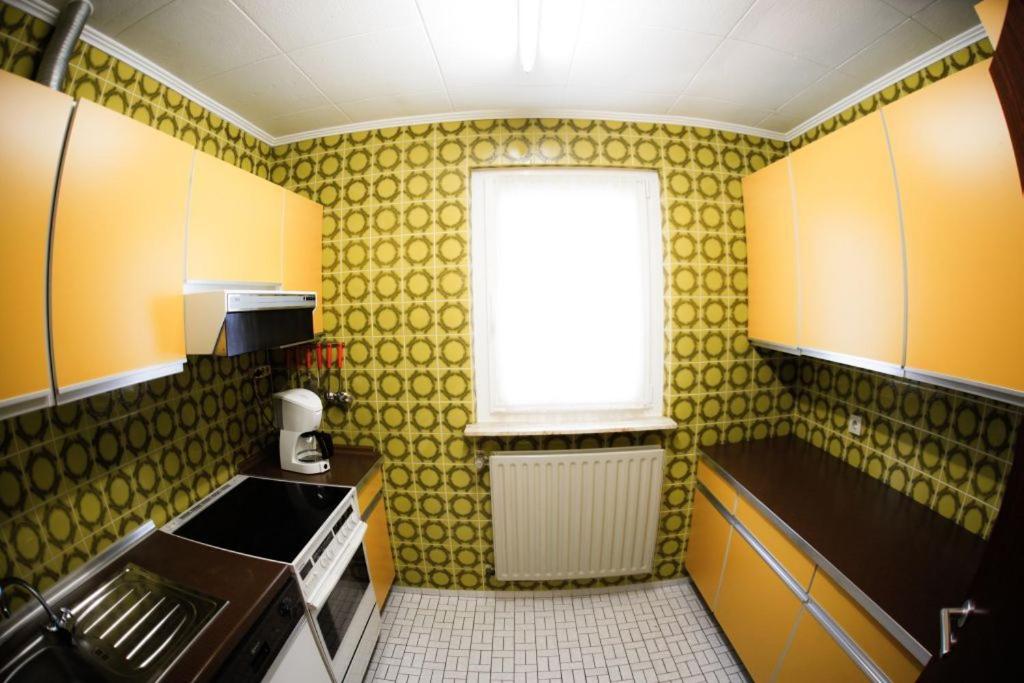 a small kitchen with yellow walls and a window at Meyer Appartments in Beaufort