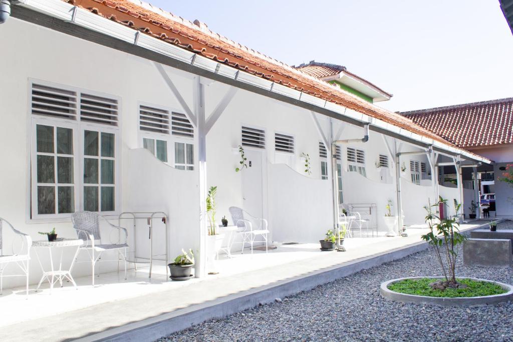 a white house with white chairs and a patio at PUTRAJAYA HOTEL in Majalengka