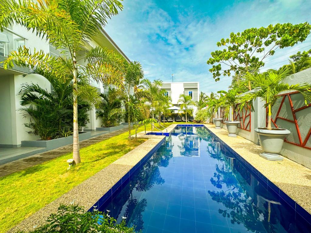 a swimming pool with palm trees next to a building at Sapphire Boutique Resort in Panglao