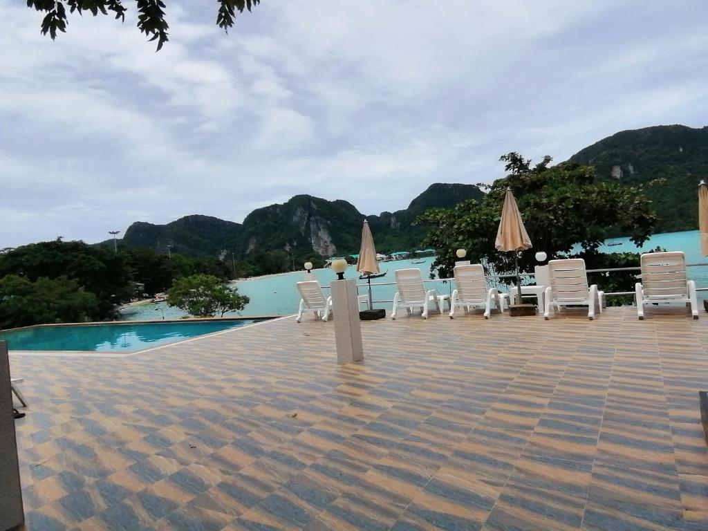 un grupo de sillas y sombrillas junto a una piscina en Phi Phi View Point Resort, en Islas Phi Phi