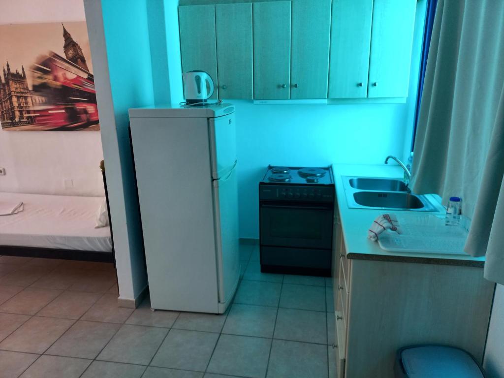 a kitchen with a white refrigerator and a sink at Serifos Palace in Livadakia