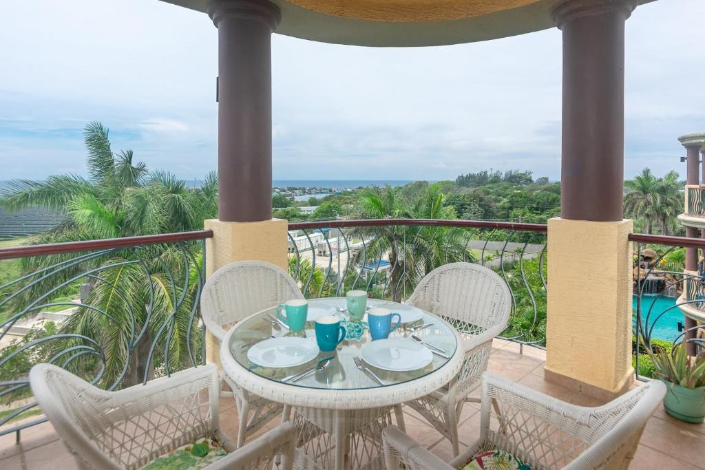 een tafel op een balkon met uitzicht op de oceaan bij Pineapple Villa 442 condo in Roatan