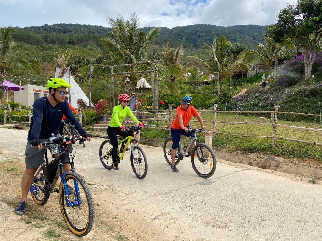 three people riding bikes down a dirt road at Khu nghỉ dưỡng Kala Campark in Tali Teurlou