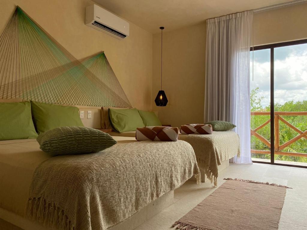 Sunsteps casa holbox في جزيرة هول بوكس: سريرين في غرفة مع نافذة