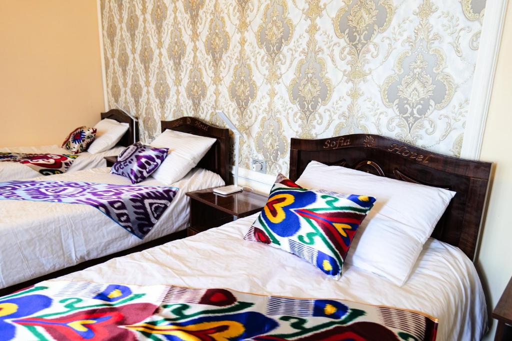 een kamer met 2 bedden en kleurrijke kussens bij "Sofia" Guest House in Samarkand