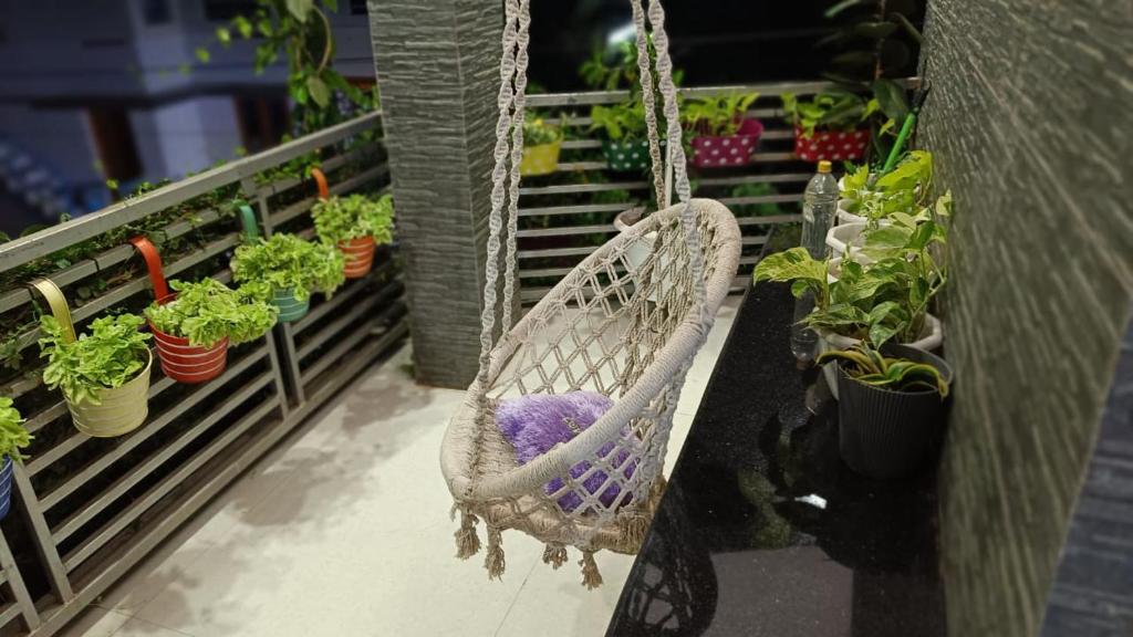 a hammock with potted plants on a balcony at Chaithritha Ladies Only Homestay in Trivandrum