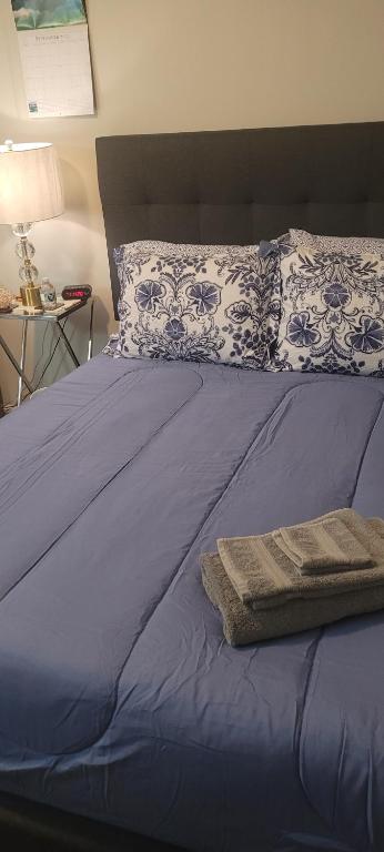 a bed with a blue comforter and pillows at Central Pointe Pad in Riverdale