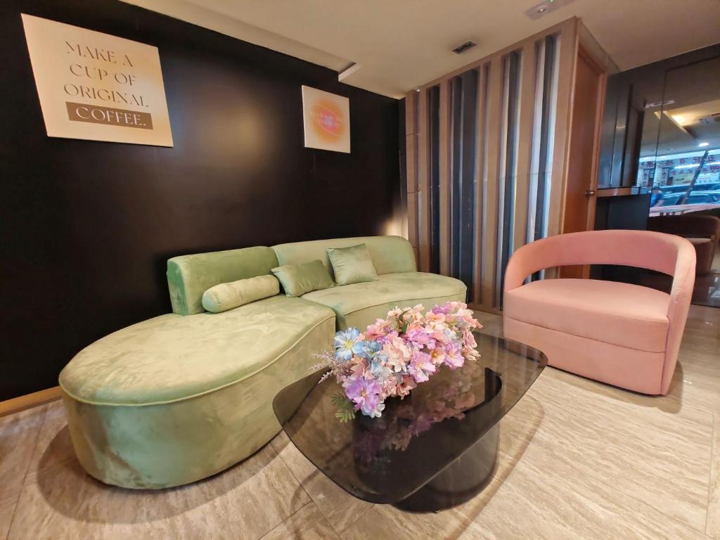 un soggiorno con divano, tavolo e sedia di Metacity MK 名廸旺角 a Hong Kong