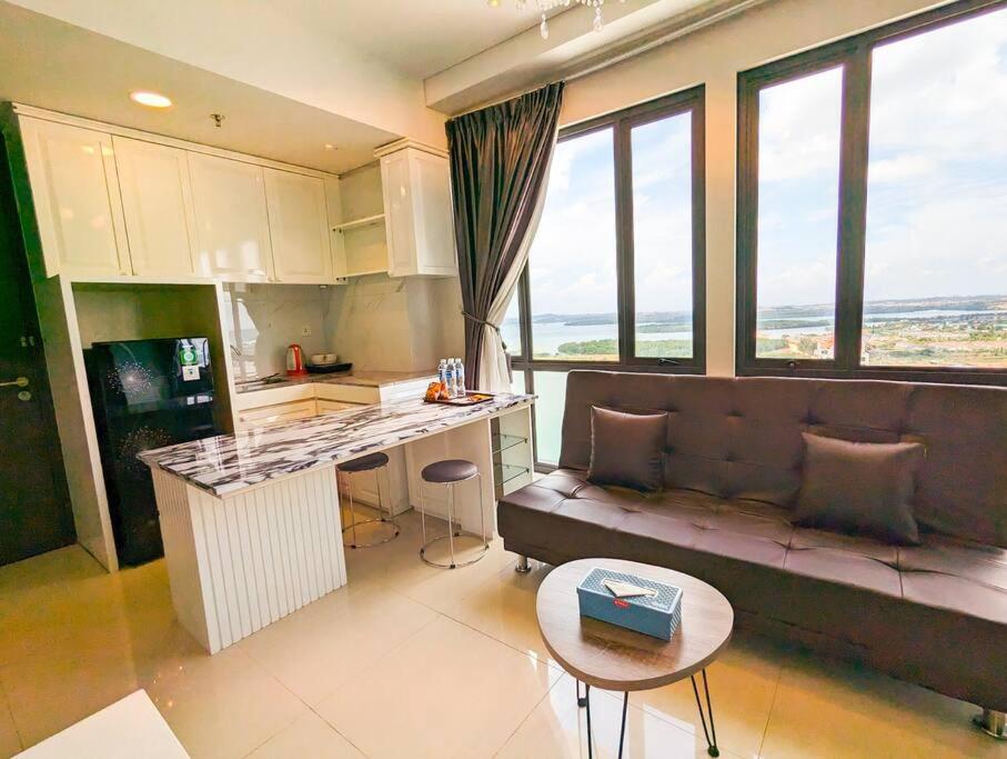 uma cozinha e sala de estar com um sofá e uma mesa em Lovina 25-AL at One Residence(near Ferry) em Batam Center