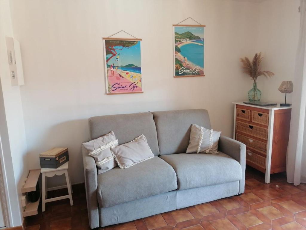 ein Wohnzimmer mit einem Sofa und einem Tisch in der Unterkunft Studio week-end mer in Saint-Cyr-sur-Mer