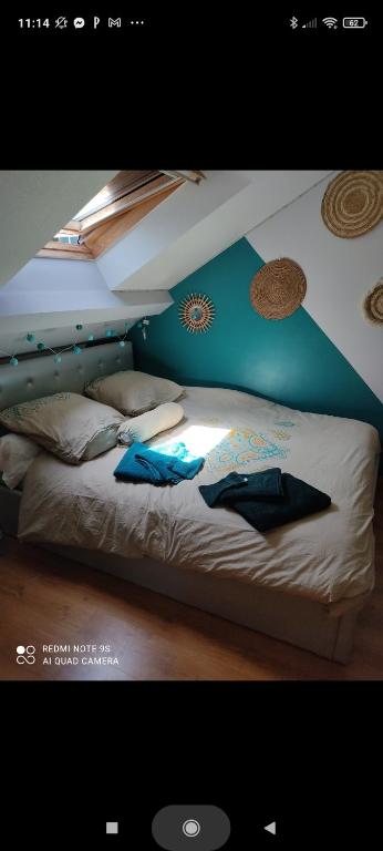 a bedroom with a bed with a blue wall at Familly 3 se trouve a 10 min du circuit des 24 h du mans 1 H 30 du péage saint Arnoult 15 min du pôle européen du cheval a savignee l&#39;évêque in Changé