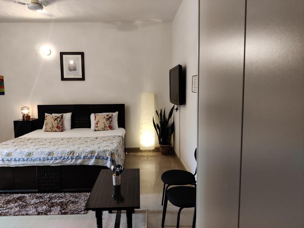 a bedroom with a bed and a table and a tv at Krishna Nivaas Homestay in Vrindāvan