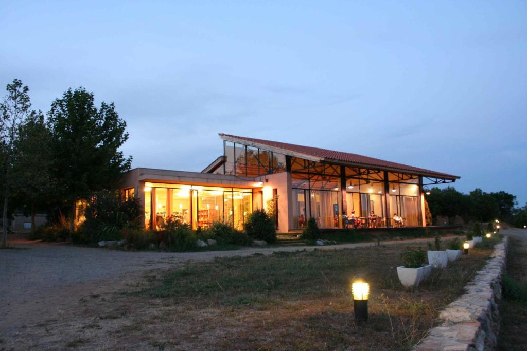 une maison avec des lumières devant elle la nuit dans l'établissement Ecològic Vinyols Camp, à Vinyols i els Arcs
