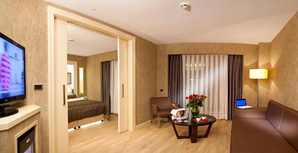 a living room with a television and a room with a bed at Limak Eurasia Luxury Hotel in Istanbul