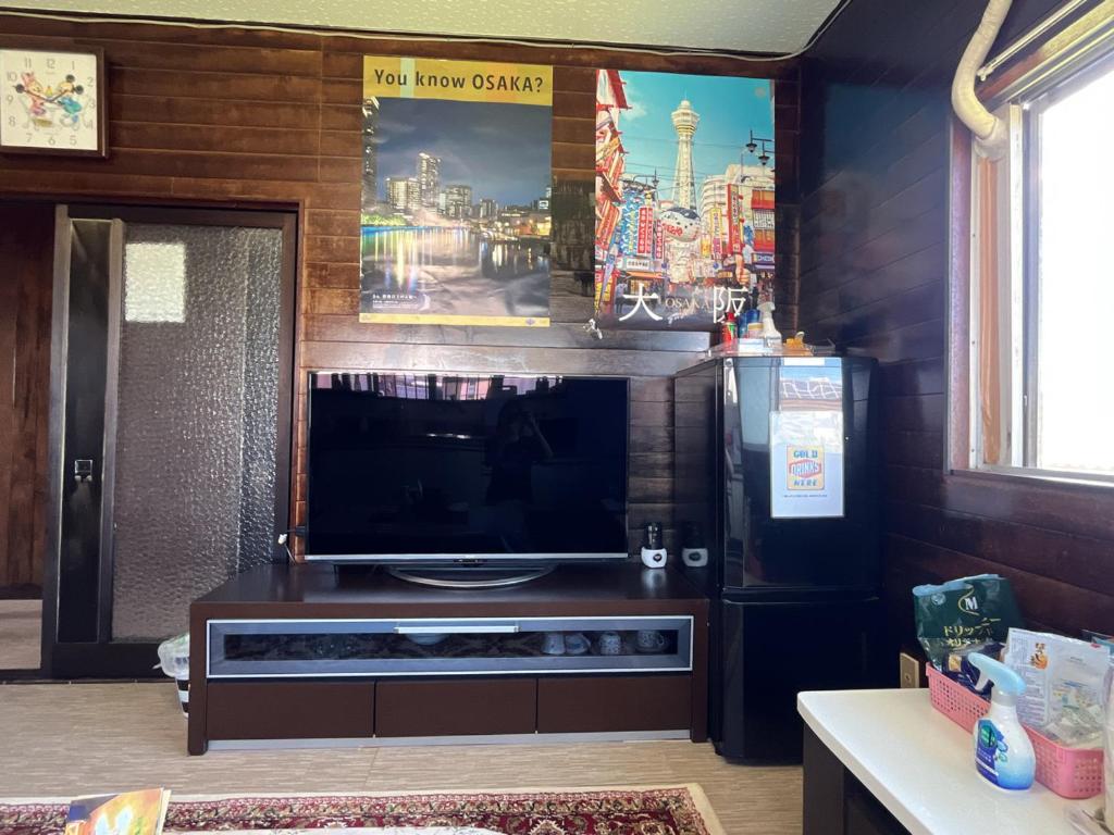 a living room with a tv and a large screen television at Airport Osaka in Kaizuka