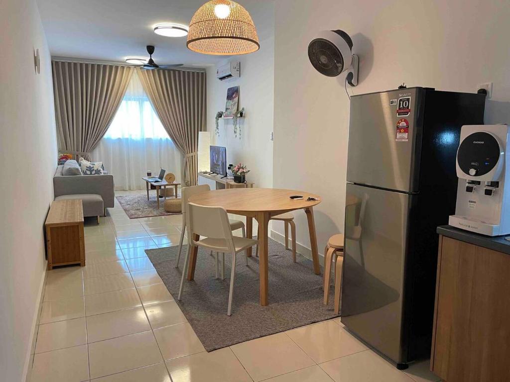 a kitchen and dining room with a table and a refrigerator at Alanis B1405 in Sepang