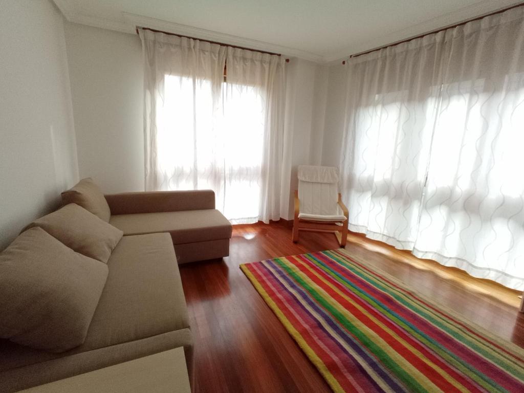 uma sala de estar com um sofá e um tapete em Apartment with parking "Hola Oviedo" em Oviedo