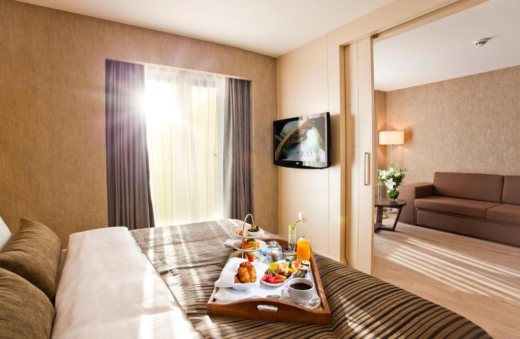 a hotel room with a tray of food on a bed at Limak Eurasia Luxury Hotel in Istanbul