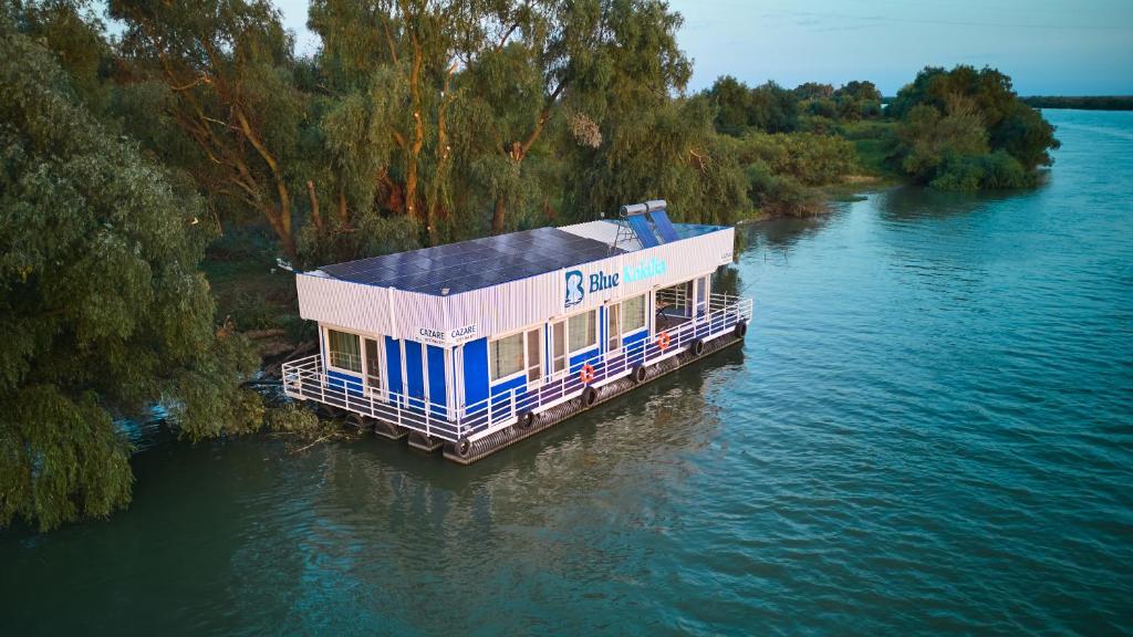 ein Haus auf einem Dock an einem Fluss in der Unterkunft Blue Kokilia in Chilia Veche