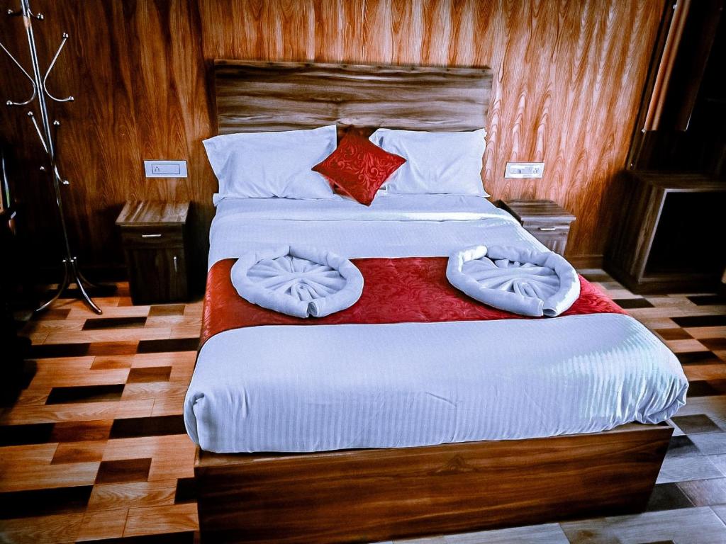 a bedroom with two beds with white sheets and pillows at Don's River Valley Jungle Resort in Maraiyūr