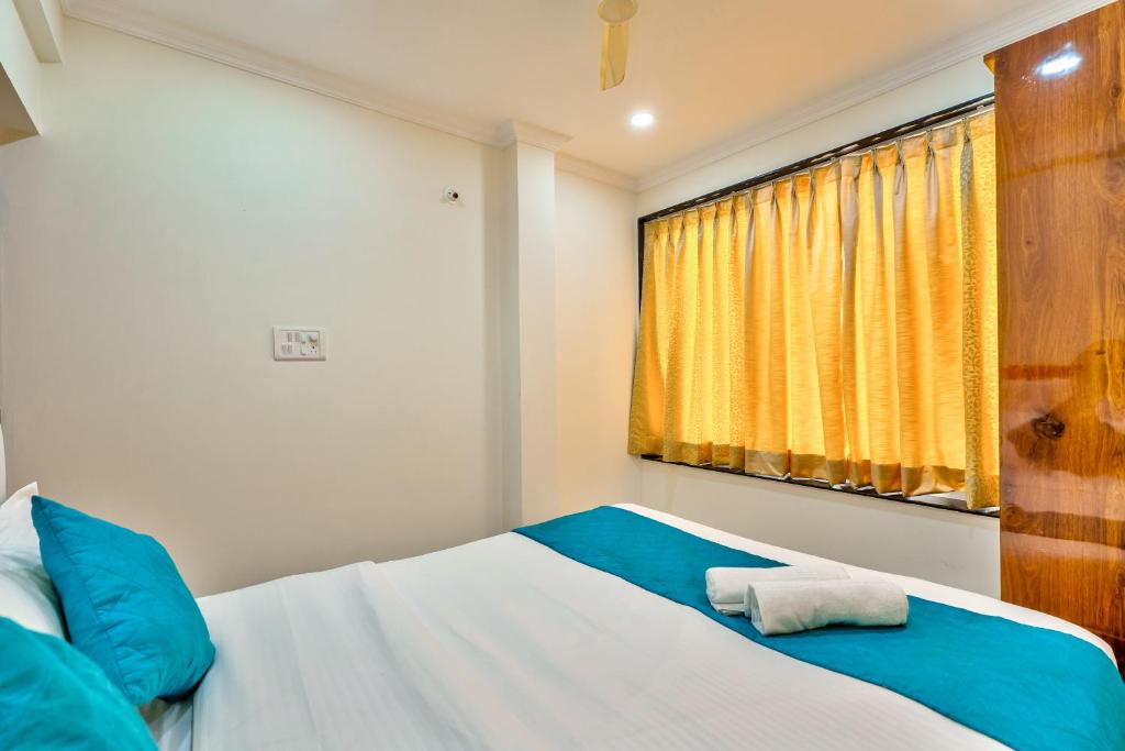 a bedroom with a bed with a yellow curtain at JOE PHILLPE APARTMENT in Old Goa