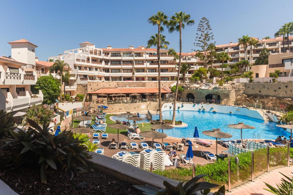 un complejo con piscina y un hotel en Oceanfront 2 bedrooms Holiday Home in Tenerife South en San Miguel de Abona