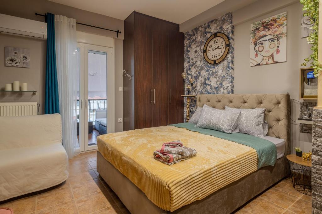 ein Schlafzimmer mit einem Bett und einer Uhr an der Wand in der Unterkunft GpxClr MediumPenthouseSuite Aplus in Larisa