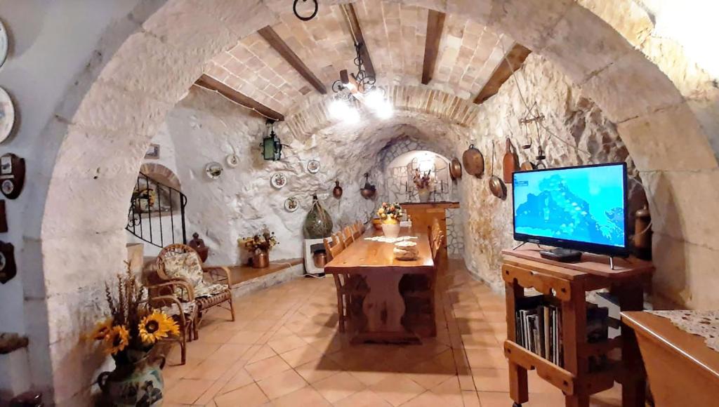 a living room with a tv and a stone wall at La grotta di NiMa in Pretoro