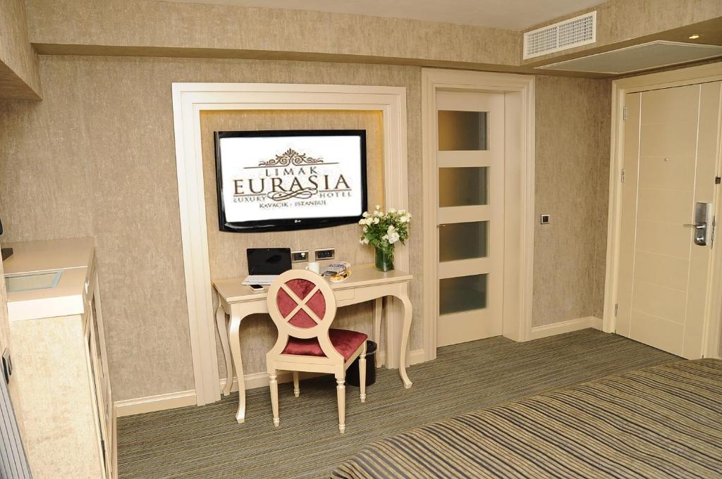 a room with a desk and a tv on a wall at Limak Eurasia Luxury Hotel in Istanbul