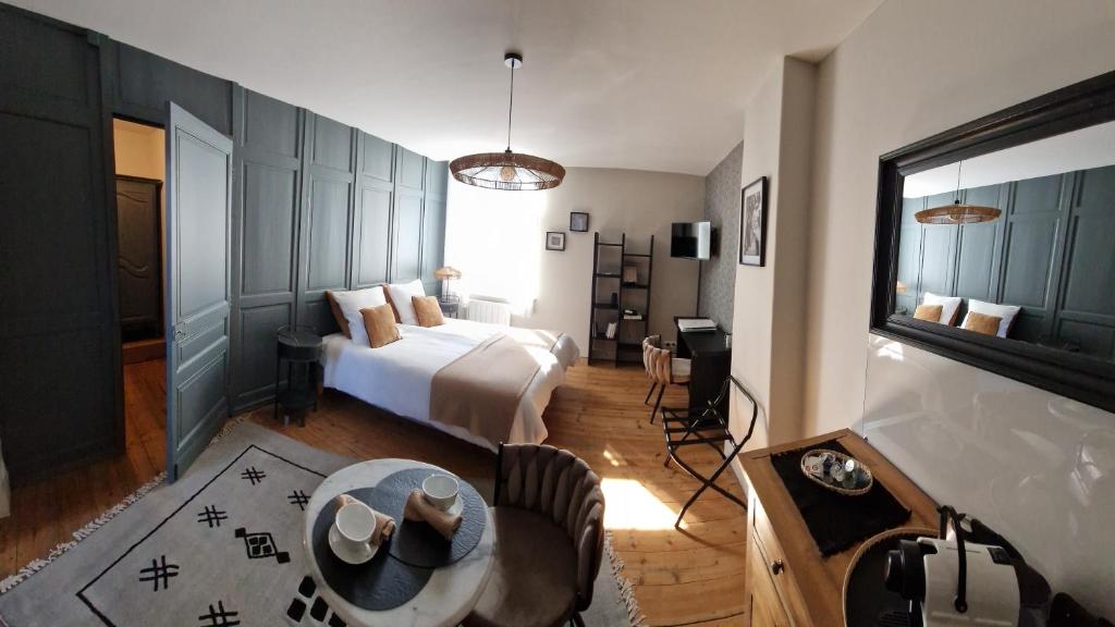 een slaapkamer met een bed en een tafel in een kamer bij Le 11 en Pévèle in Templeuve