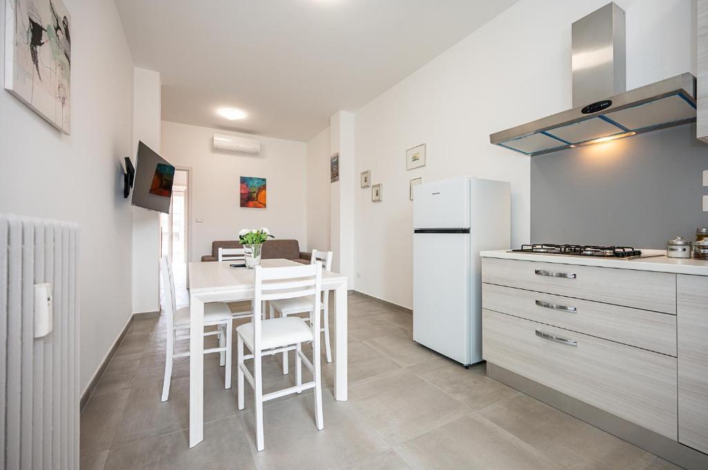 a kitchen with a white table and a white refrigerator at Appartamento Esclusivo - Zona Metro Massaua-Marche Torino in Turin